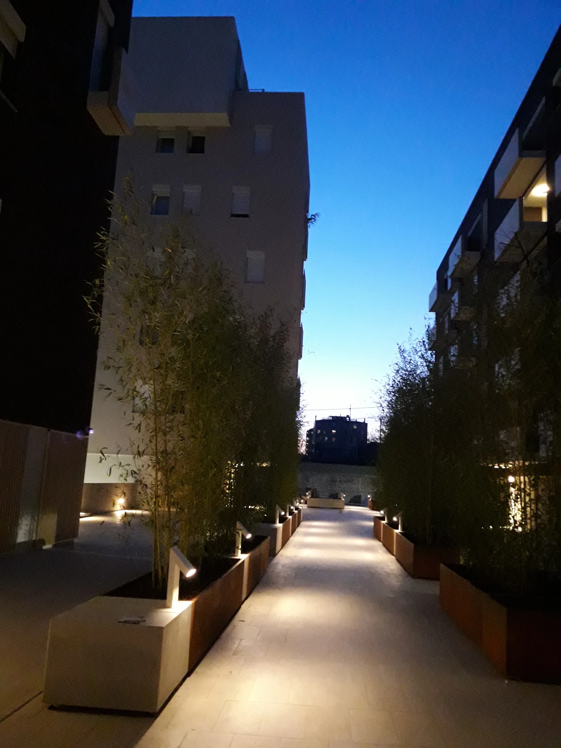 Abitare in Poste — Via Tirone — Percorso pedonale illuminato tra gli edifici