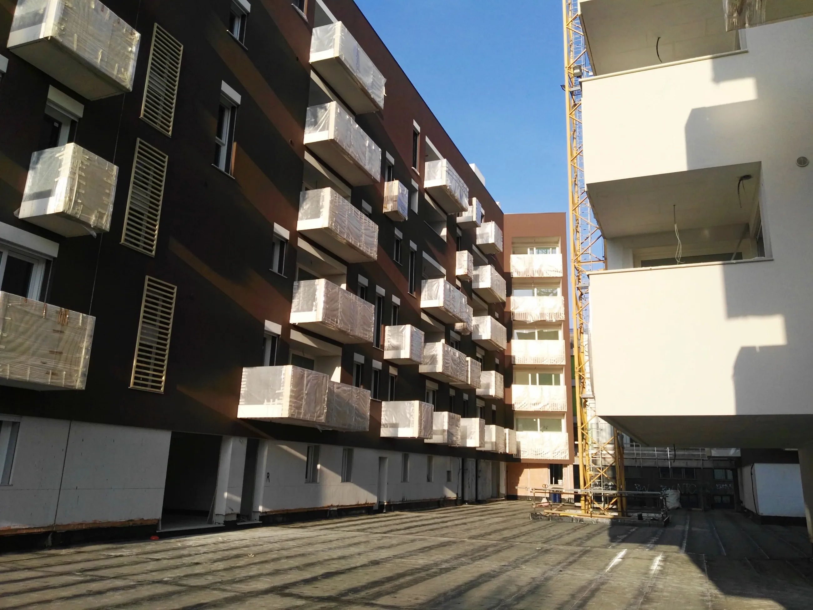 Abitare in Poste — Via Tirone — Corte tra i fabbricati con balconi e rivestimenti