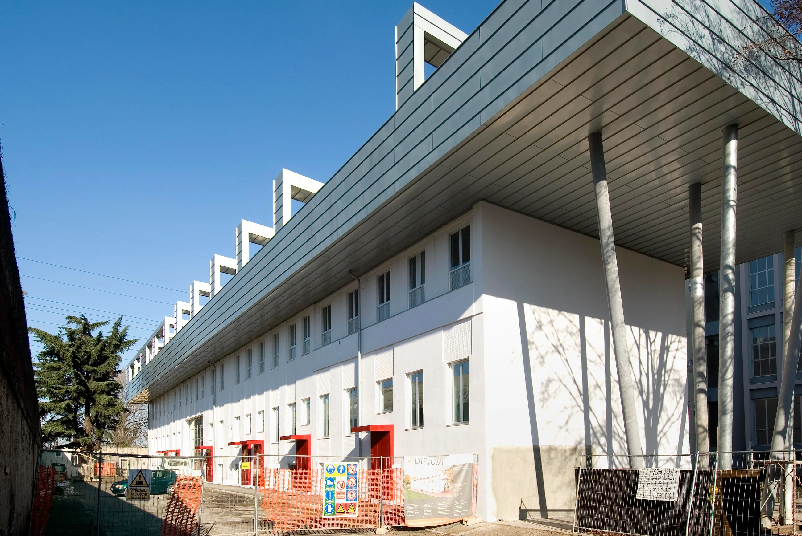 Vista della facciata bianca e della copertura lungo il cantiere