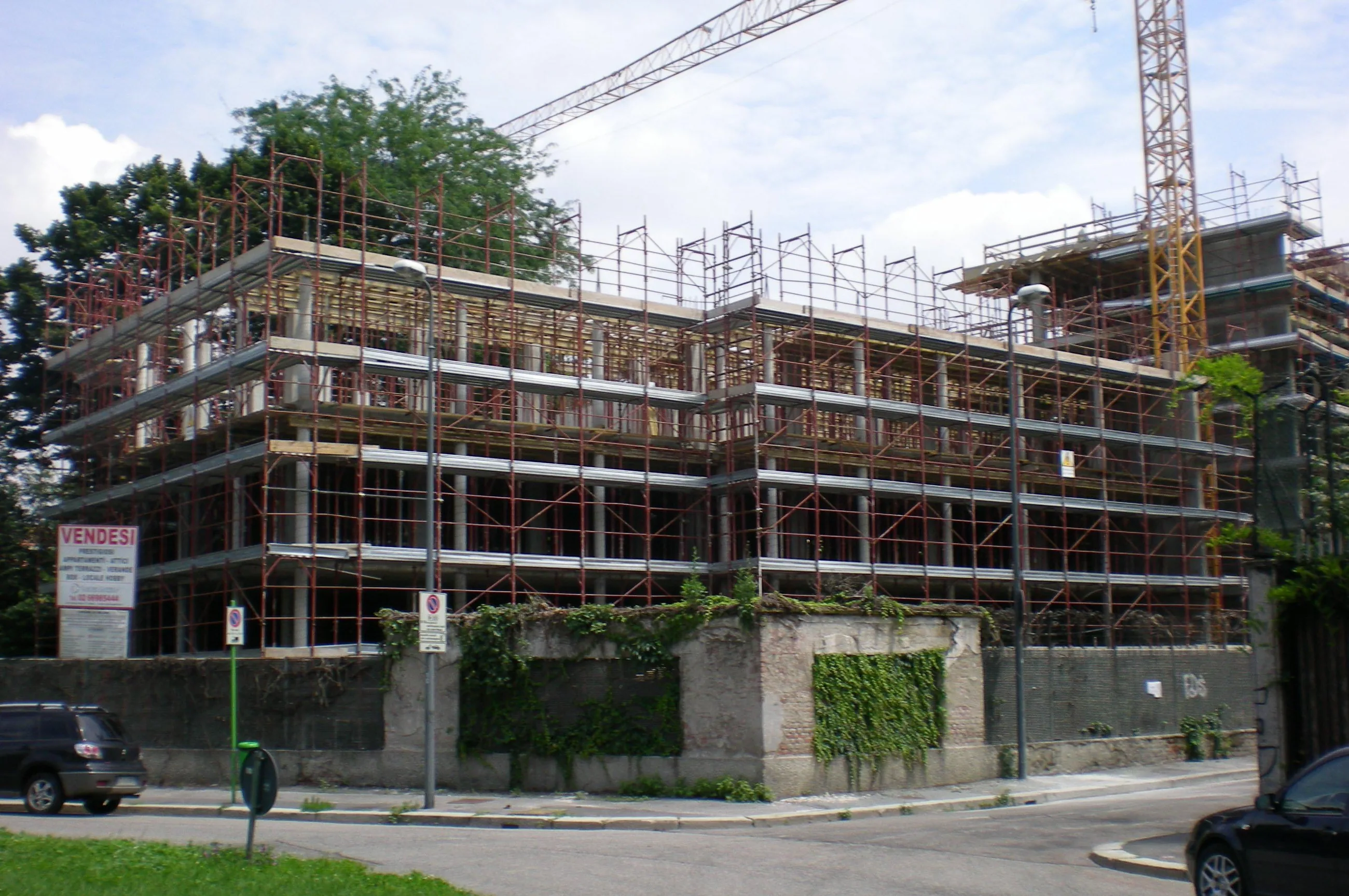 Struttura del fabbricato in costruzione con ponteggi e gru